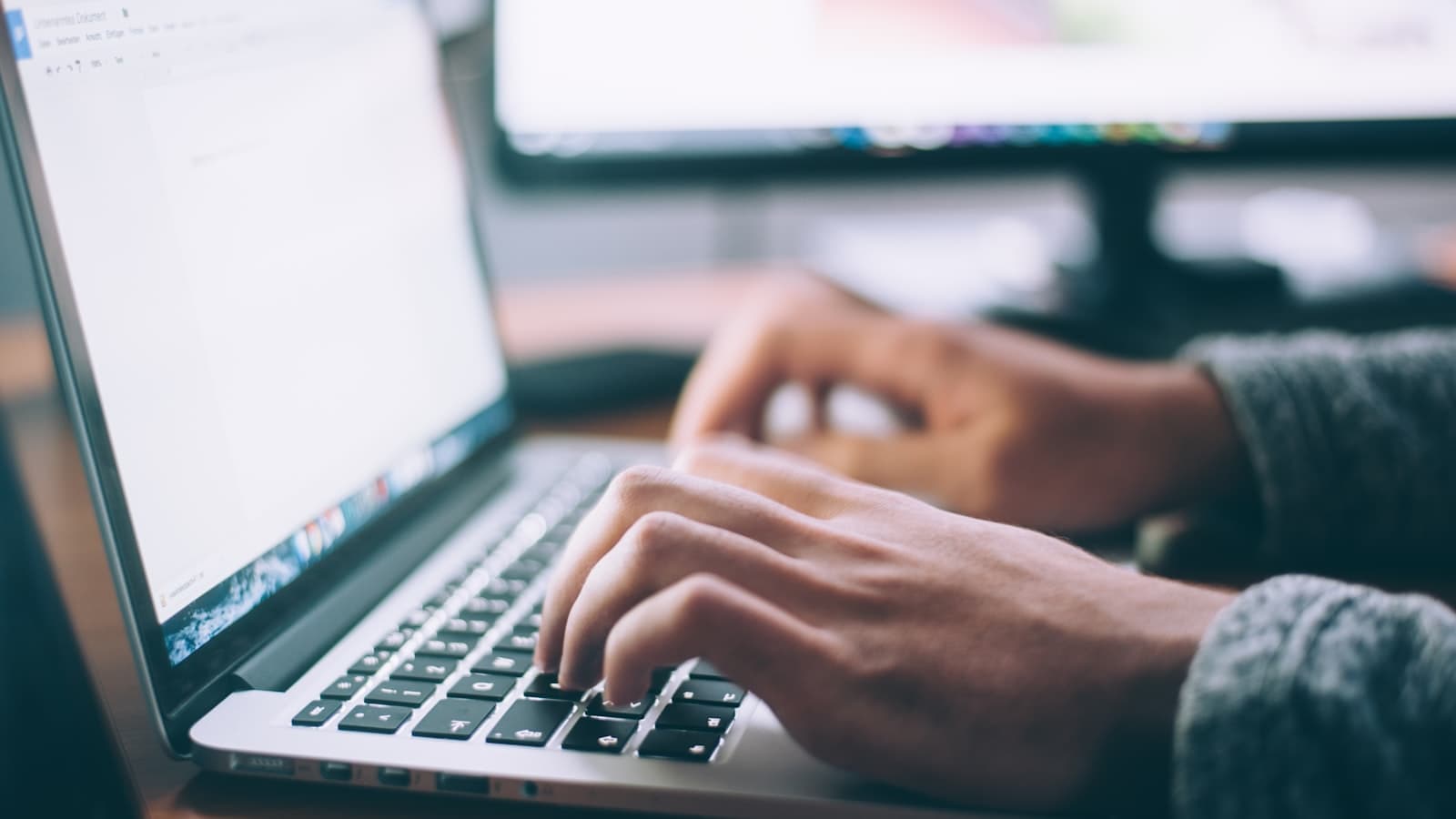 Person on a laptop call with documents nearby