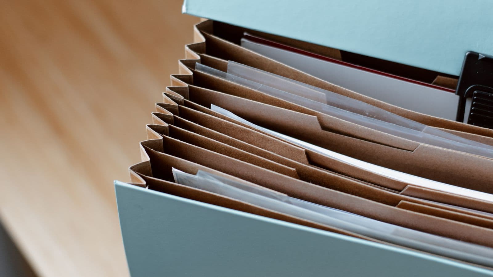 Expanding file folder with household paperwork on a wooden desk